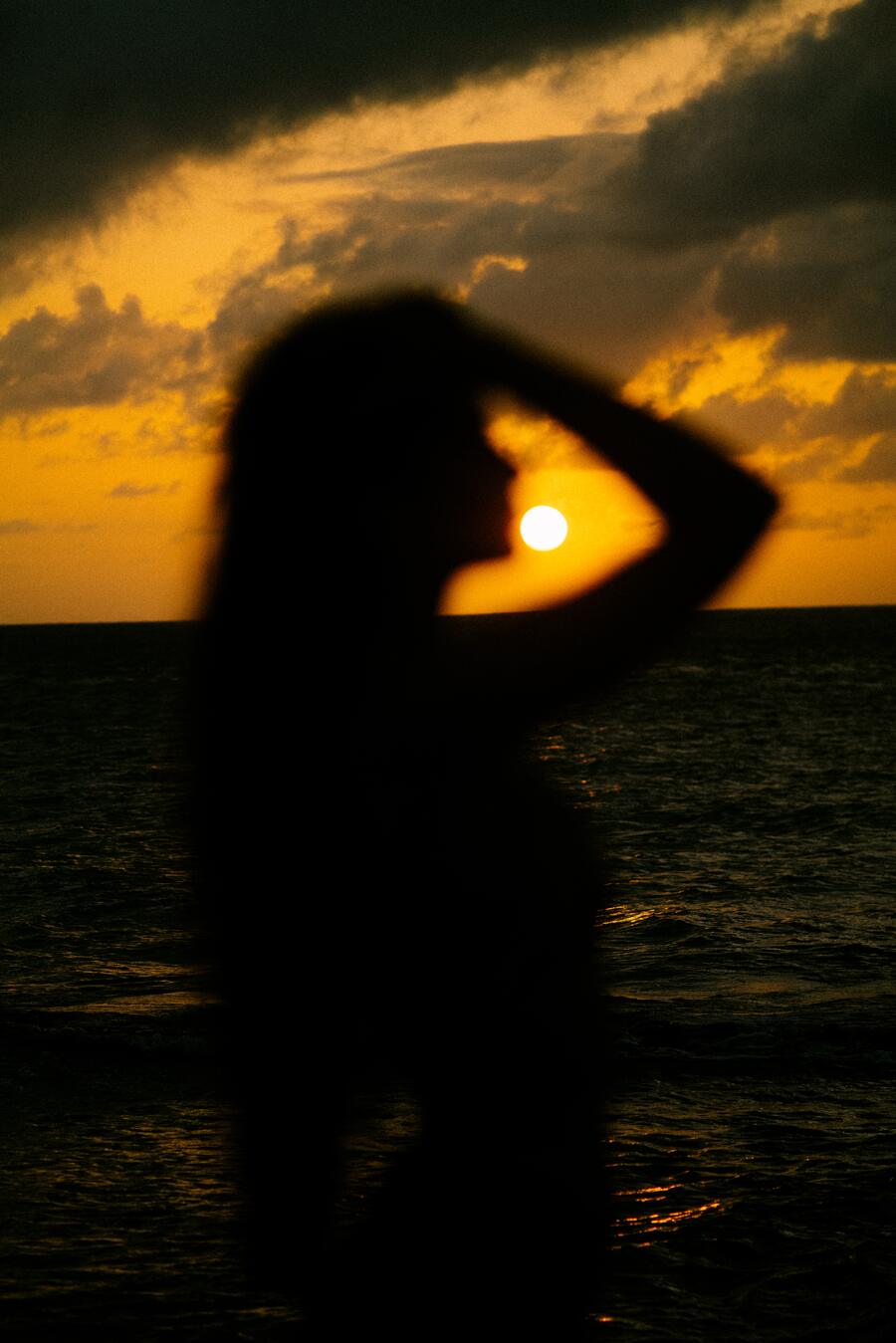 Her silhouette against the burning sky.